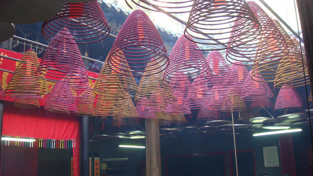 Here are some spiral incense candles hanging from the ceiling of a temple.